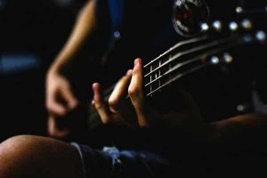 Gros plan sur les doigts d'une bassiste en train de jouer